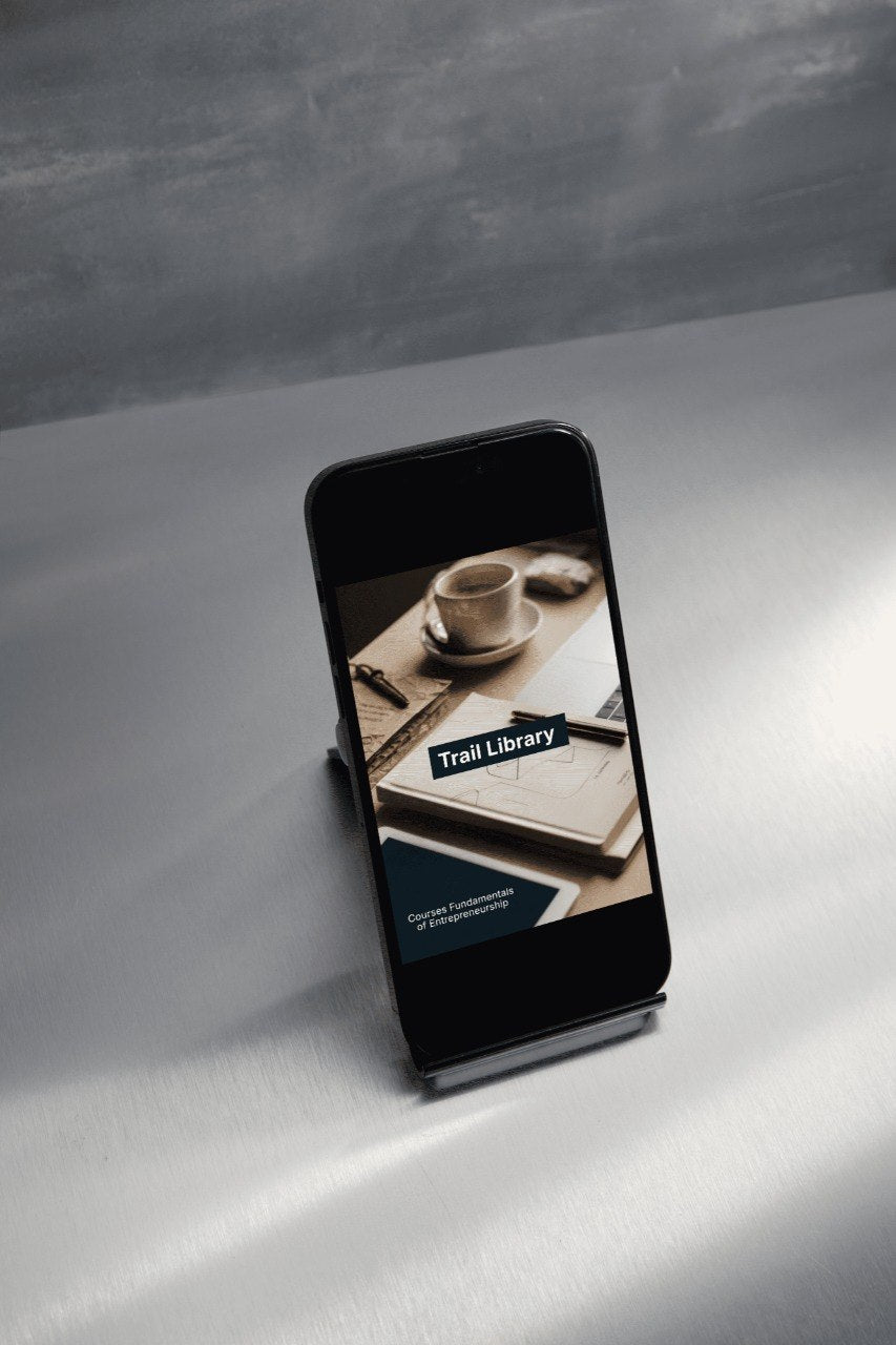 Phone displaying a 'Trail Library' app on a gray surface