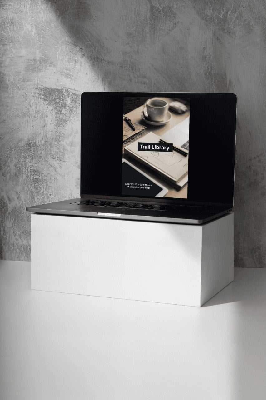 Laptop on a white stand with a black screen displaying an image of a book and a cup.